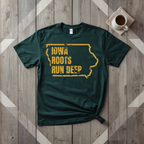Iowa Roots Run Deep tee in forest green with mustard print, laid flat on weathered wood