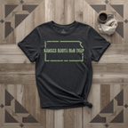 Kansas Roots Run Deep tee in black with sage print, laid flat on weathered wood