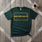 Kansas Roots Run Deep tee in forest green with mustard print, laid flat on weathered wood