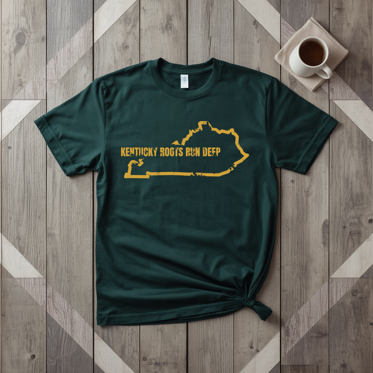 Kentucky Roots Run Deep tee in forest green with mustard print, laid flat on weathered wood