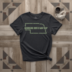 Nebraska Roots Run Deep tee in black with sage print, laid flat on weathered wood
