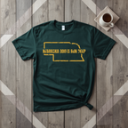 Nebraska Roots Run Deep tee in forest green with mustard print, laid flat on weathered wood