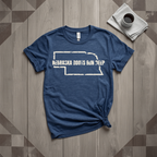 Nebraska Roots Run Deep tee in heather navy with cream print, laid flat on weathered wood