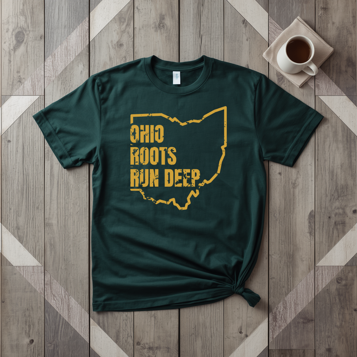 Ohio Roots Run Deep tee in forest green with mustard print, laid flat on weathered wood