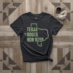Texas Roots Run Deep tee in black with sage print, laid flat on weathered wood