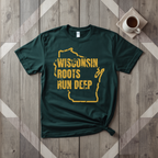 Wisconsin Roots Run Deep tee in forest green with mustard print, laid flat on weathered wood